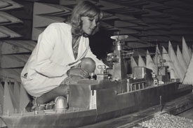 Computer programmer using scale-model to test positioning of corvette's radio antennas.