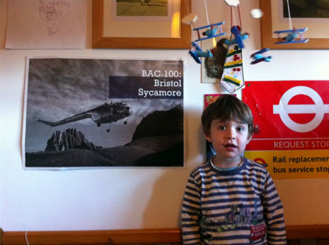 Luka with his poster of a Bristol Sycamore which has pride of place in his bedroom. Luka fell in love with helicopters when one landed in the park opposite the flats where he lives.